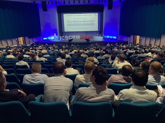 Voller Konferenzsaal bei der ICSCRM 2023, von den hinteren Reihen aus gesehen